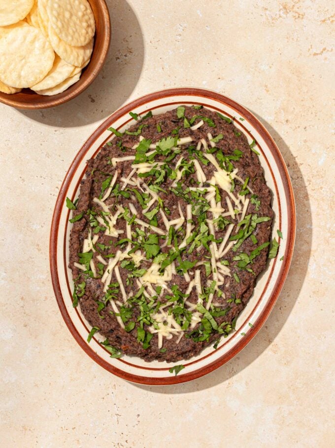 black bean dip on plate with crackers in bowl