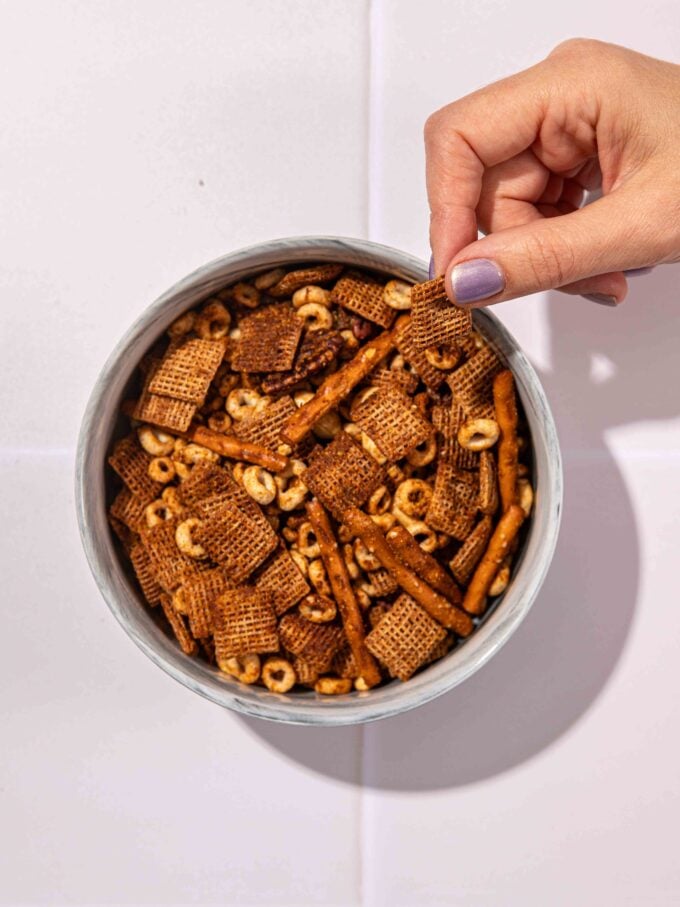 hand with bowl of chex mix