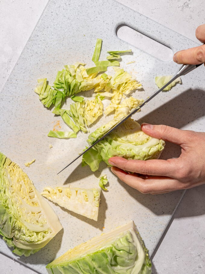 hand shredding cabbage with a knife