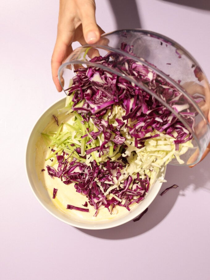 pouring cabbage into white bowl