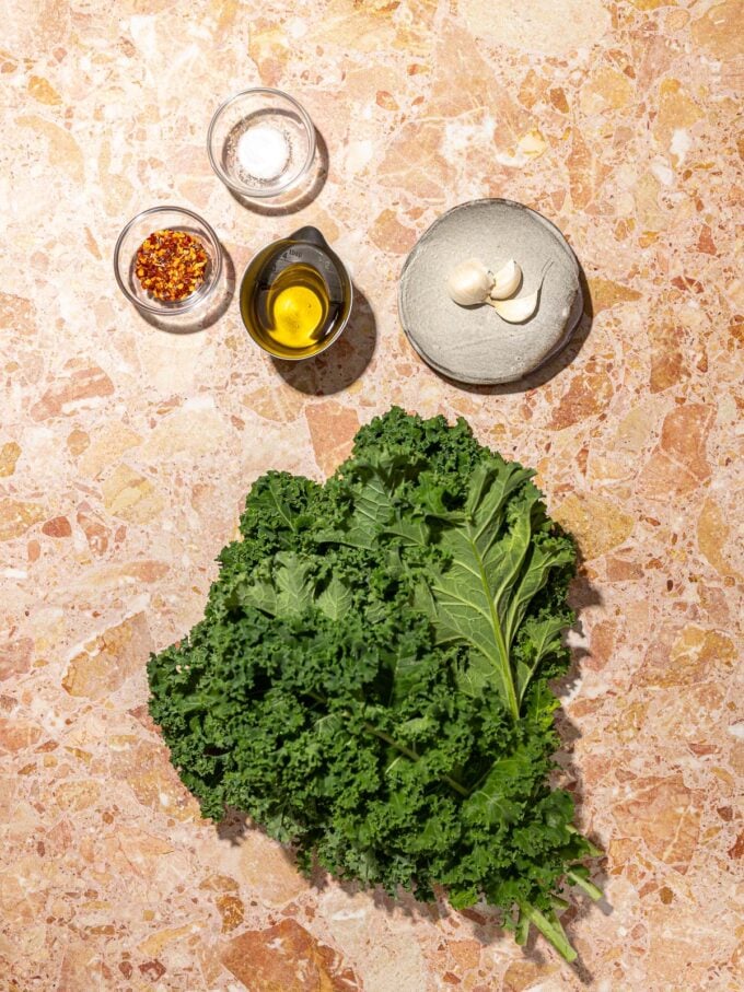 kale, oil, garlic and chile flakes in bowls