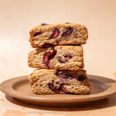 3 whole grain cherry scones stacked on brown plate