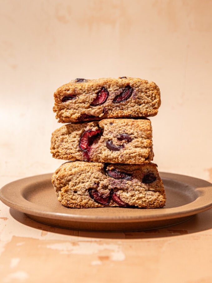 3 whole grain cherry scones stacked on brown plate