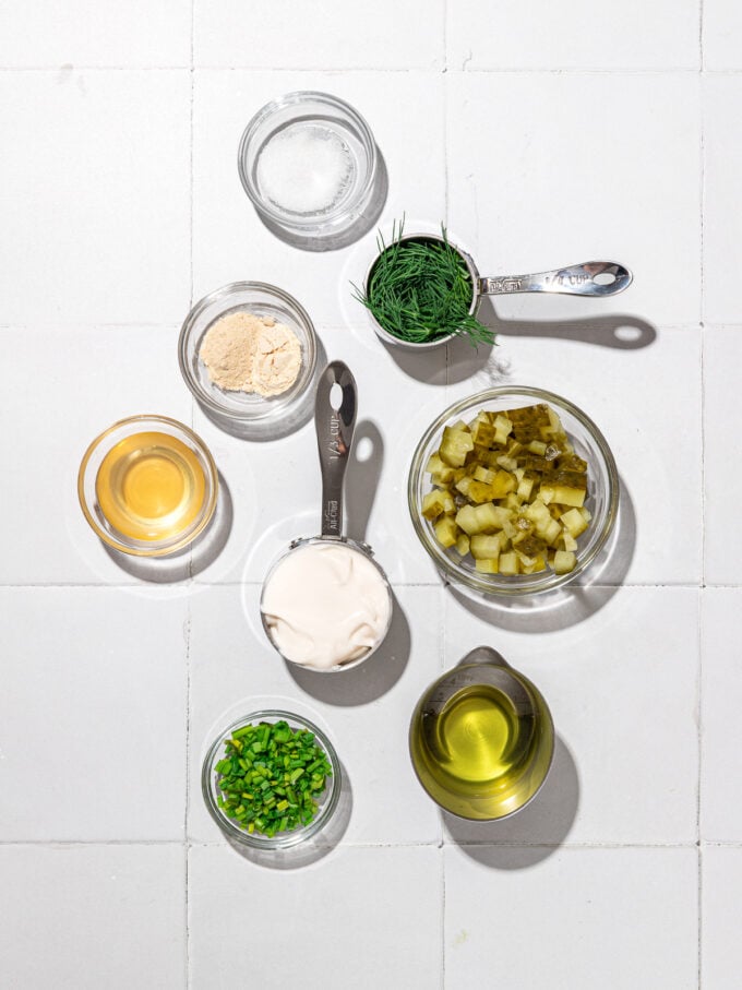 bowls of chopped pickles, dill, chives and oil