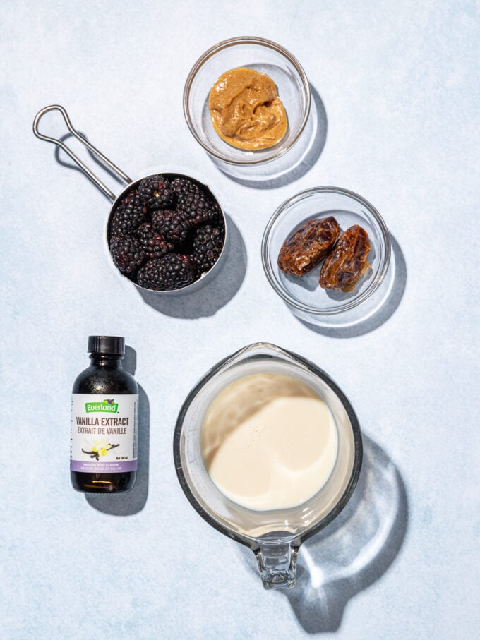 bowls of milk, dates, peanut butter and blackberries