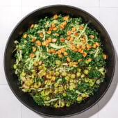 kale and cabbage salad with corn nuts in black bowl