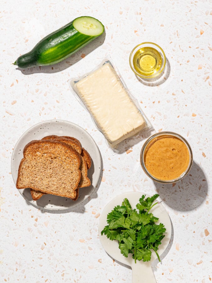 bread, tofu, cucumber, cilantro on terrazzo background