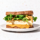 tofu sandwich with peanut sauce and cilantro on white plate