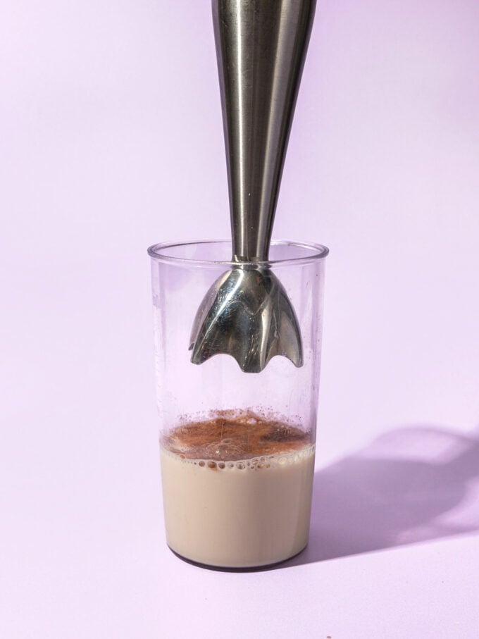 immersion blender in cup of milk and cinnamon