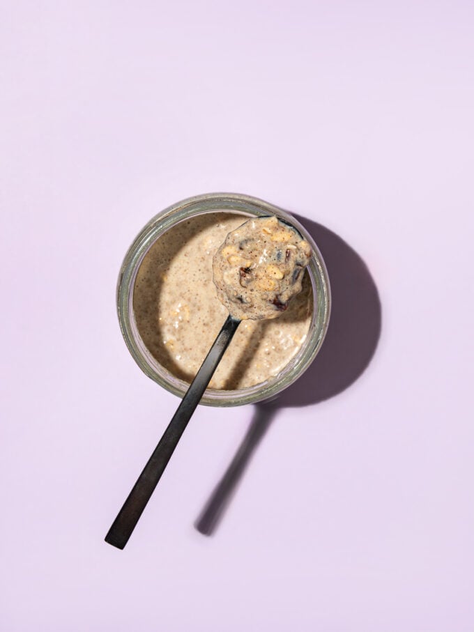 black spoon of overnight oats on top of jar