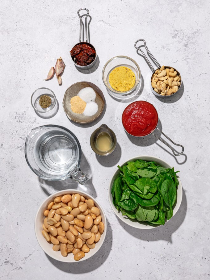 bowls of butter beans, spinach, passata, cashews and spices