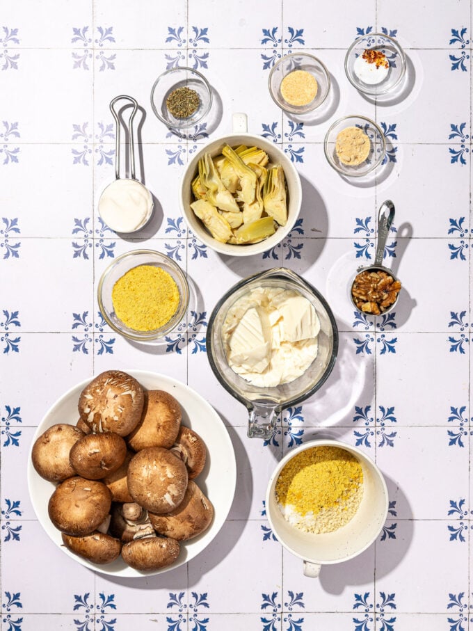 bowls of mushrooms, soft tofu, artichoke hearts and mayo on tile background