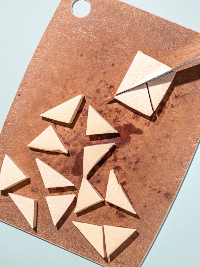 knife slicing tofu into triangles